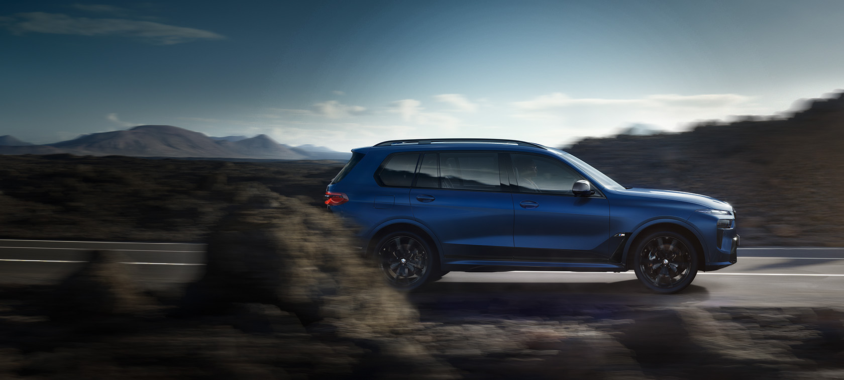 BMW X7 M60i xDrive G07 LCI Frozen Marina Bay Blue sidvy körande på väg