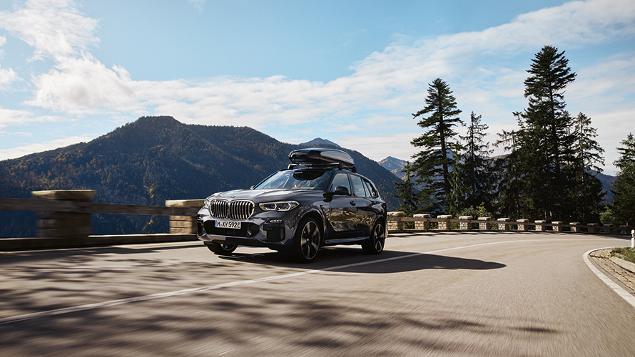 BMW med takbox på landsväg.